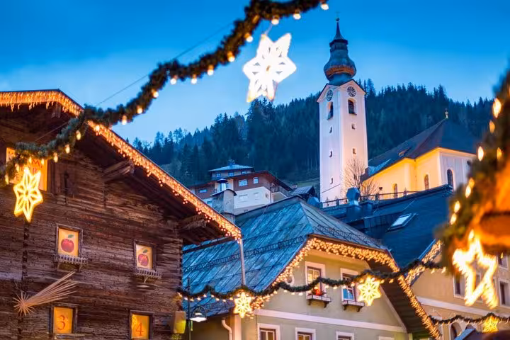 Festive Salzburg old town with glowing Christmas lights and church tower, Vienna to Salzburg day tour