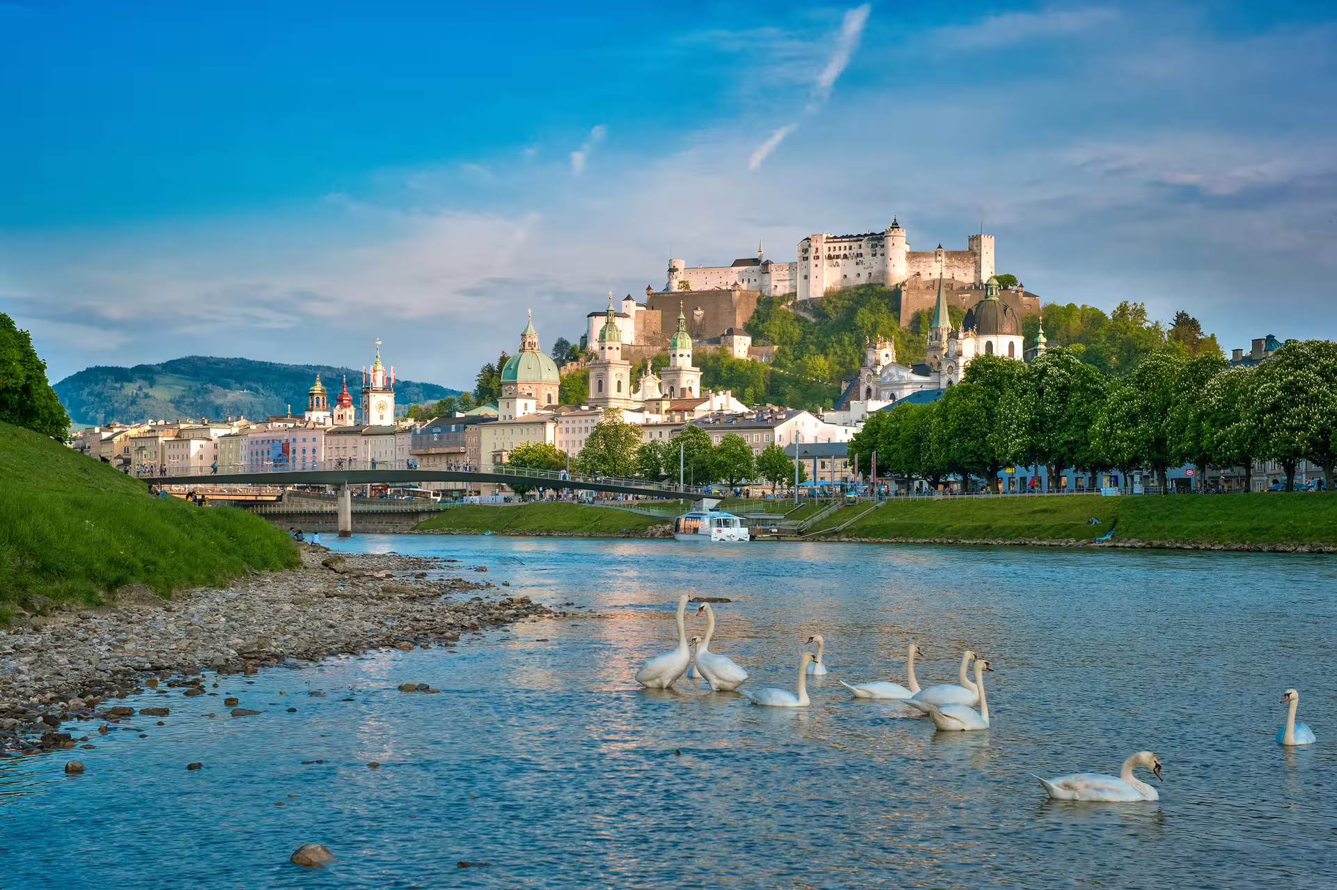 Picturesque Salzburg with Hohensalzburg Fortress and swans on the Salzach River, ideal for private city tours.