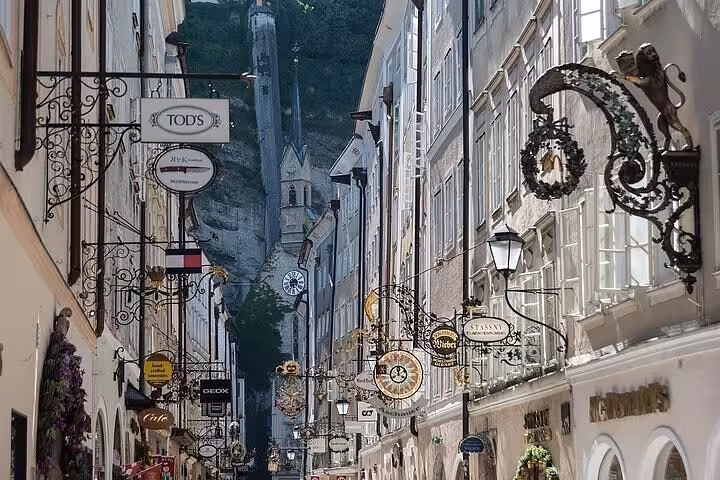 Salzburg old town shopping street with ornate signs, perfect stop on a Vienna to Munich private transfer tour