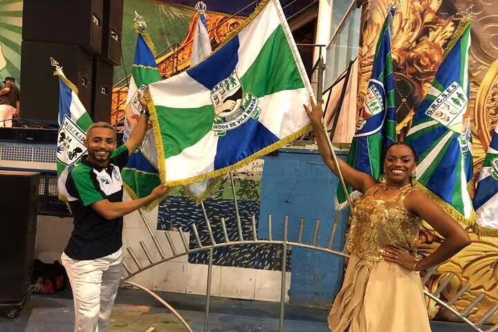 Proud samba school members holding flags at São Paulo Carnaval rehearsal, highlighting cultural pride and tradition.