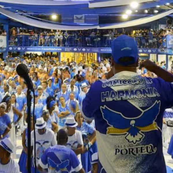 Leader energizes the crowd at a bustling samba school rehearsal, immersing participants in Rio's carnival spirit.