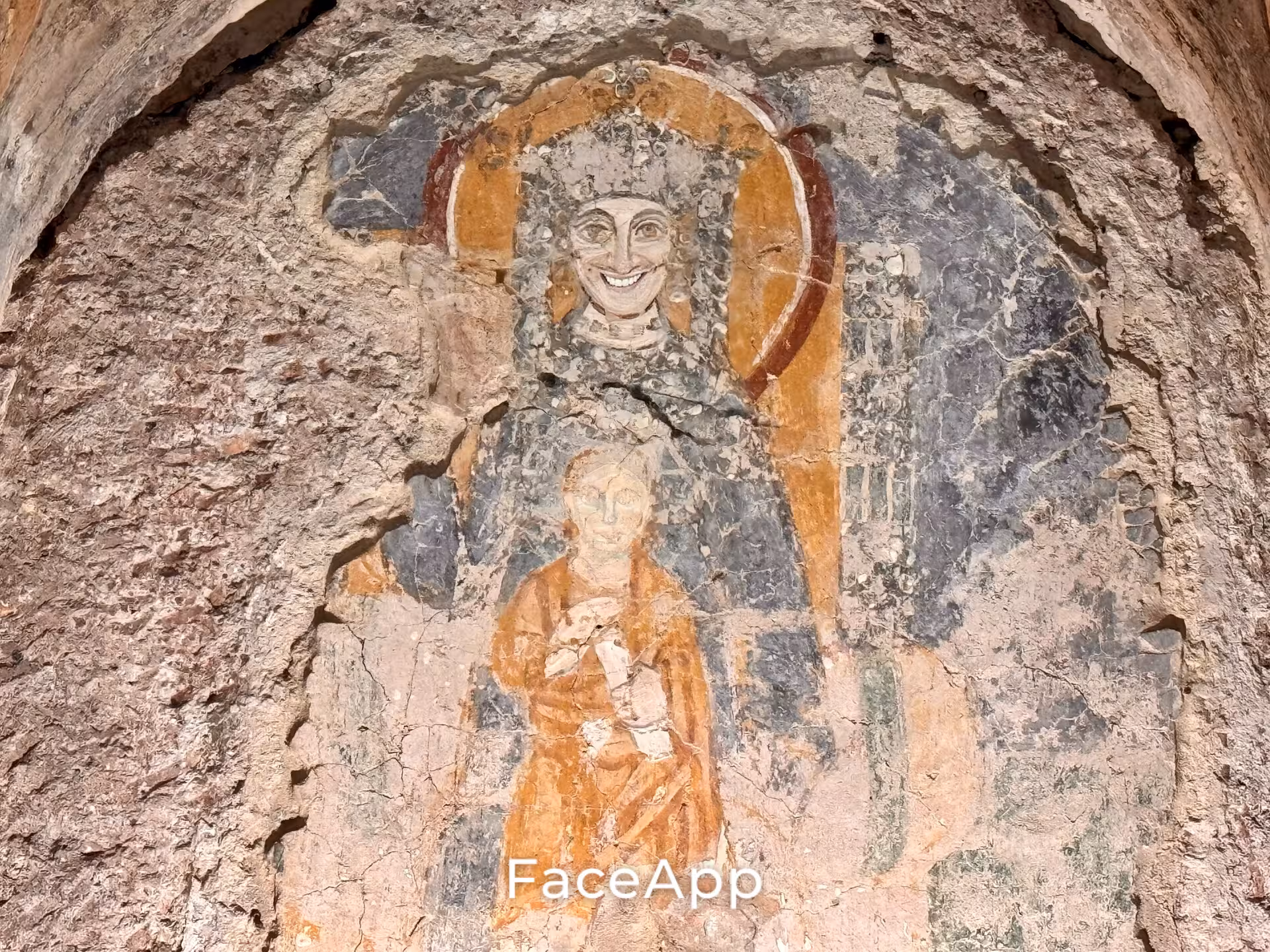 Faded medieval fresco of a haloed saint and child in the underground levels of San Clemente Basilica in Rome, Italy