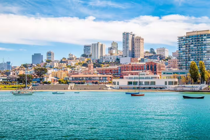 San Francisco waterfront at Hyde Street Pier with sailboats, historic buildings, and city skyline