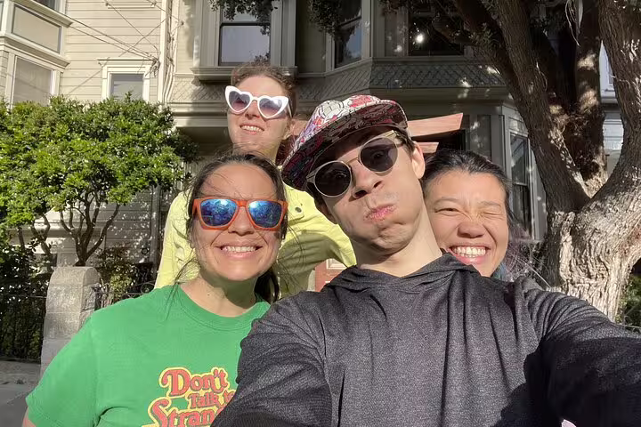 Four friends taking a selfie with fun sunglasses during a San Francisco walking tour