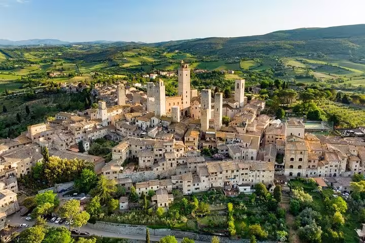 Aerial view of historic San Gimignano's medieval towers and scenic countryside, a highlight of Chianti private tours.