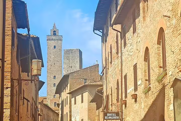Medieval stone towers and narrow lane in historic San Gimignano, a highlight stop on a private Chianti hills wine tour