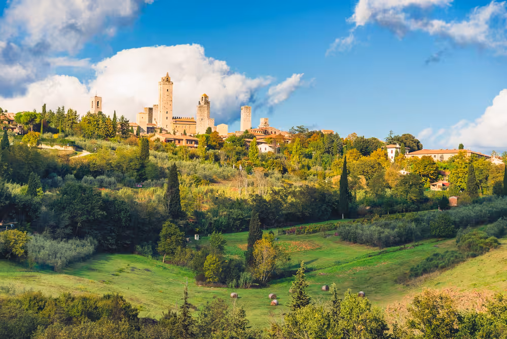 Breathtaking panorama of San Gimignano's medieval towers surrounded by verdant Tuscan countryside.