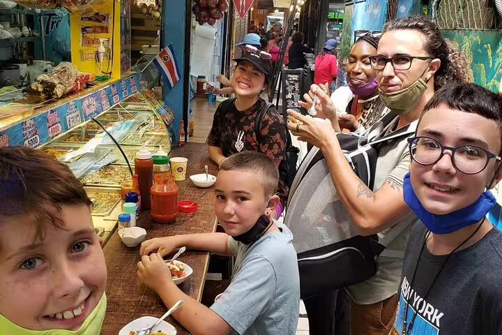 A group enjoys local cuisine at a San Jose market during the Bites and Sights Walking Food Tour and National Museum visit.