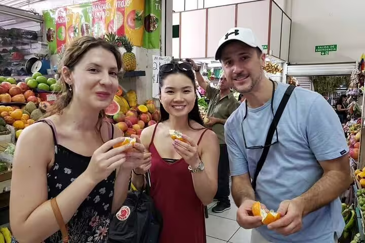 Participants savor fresh fruit at a vibrant San Jose market on the walking food tour.
