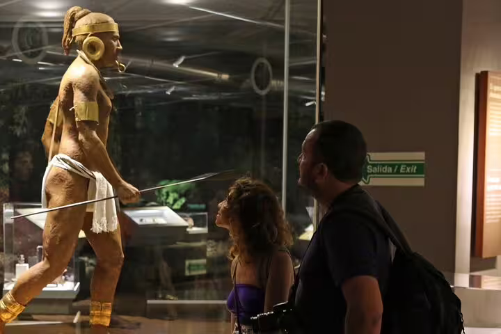 Visitors admire an indigenous warrior statue at the National Museum in San Jose, part of the walking food tour.