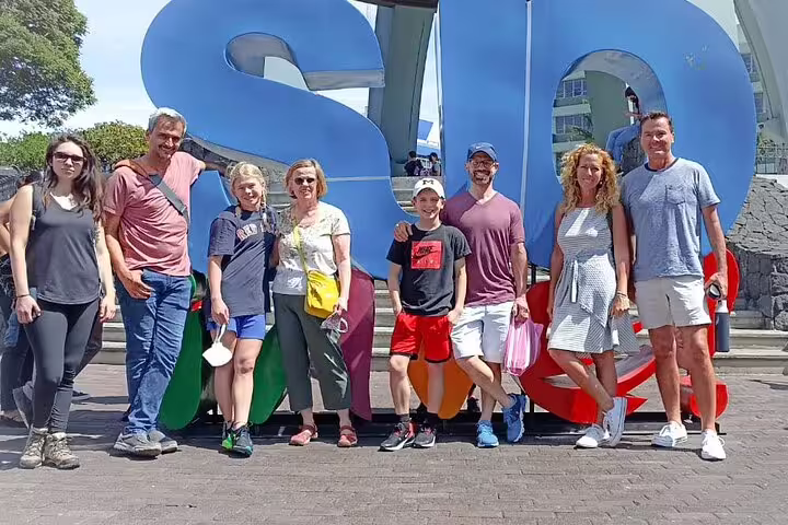 Group of tourists pose in front of iconic San Jose sign during the Bites and Sights Walking Food Tour.