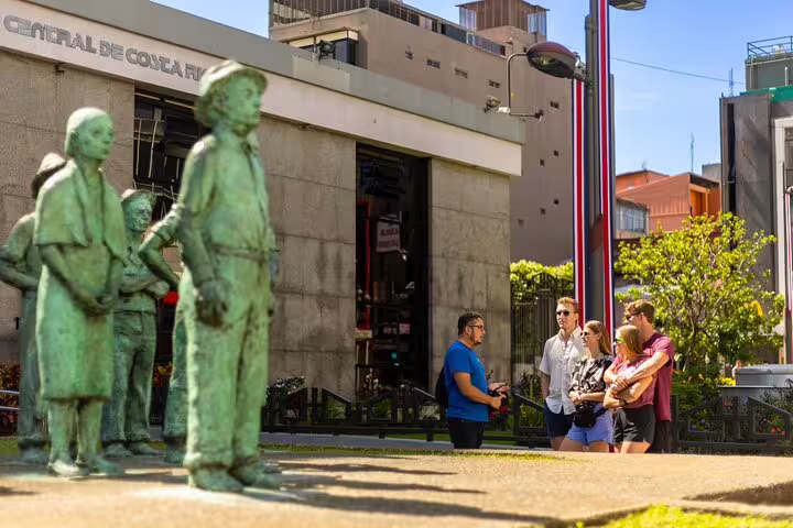 Tourists explore San Jose's vibrant streets with bronze statues and modern architecture on a Bites and Sights walking tour.