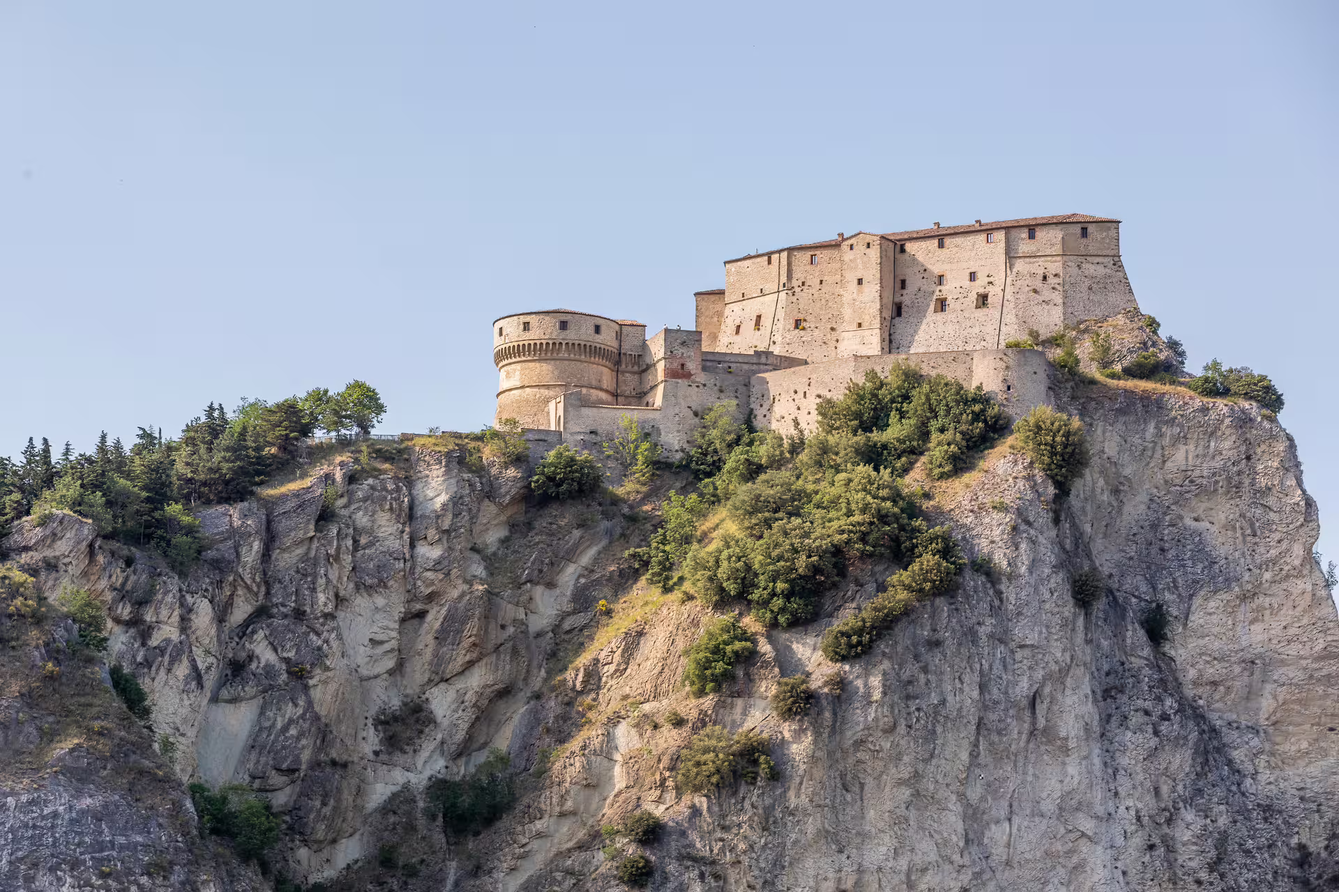 Close-up of San Leo Fortress sitting atop a steep cliff, highlighting its impressive medieval structure and scenic backdrop.