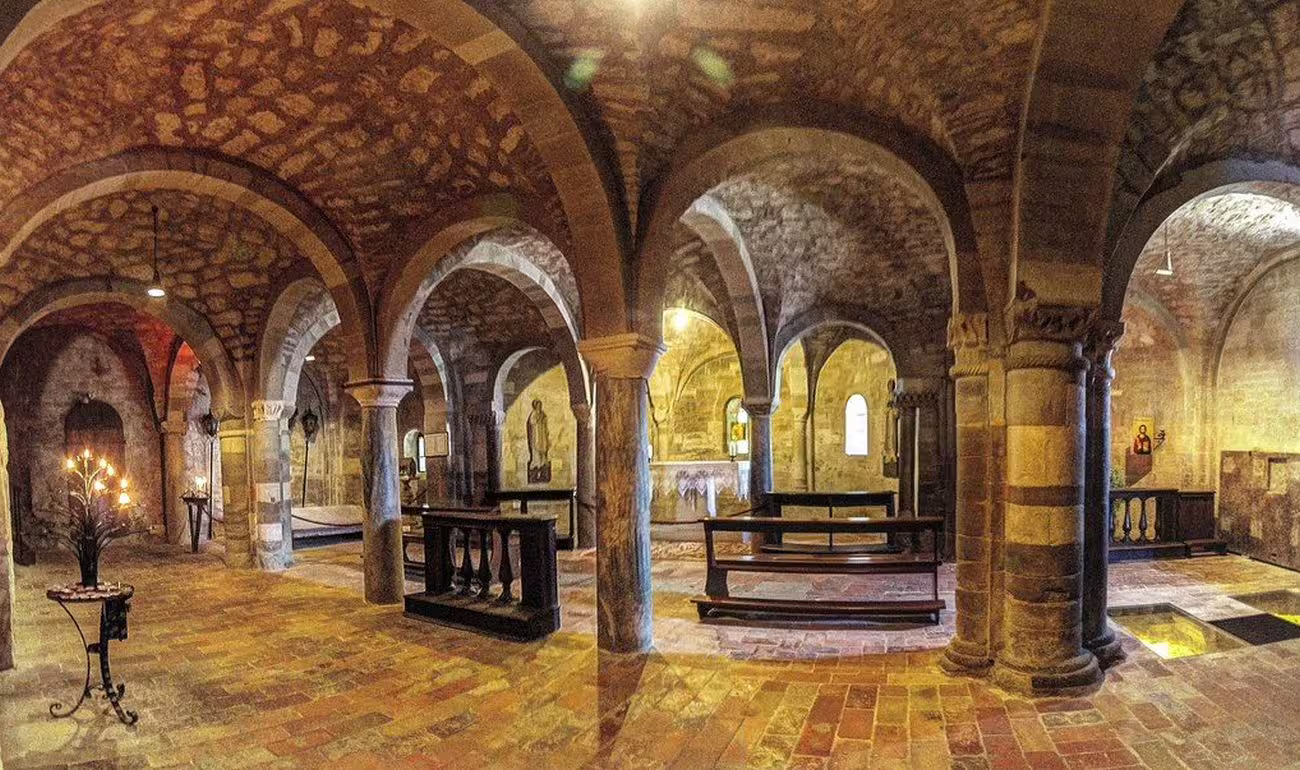 Inside the historic San Leo Fortress, showcasing medieval architecture with stone arches and dimly lit ambiance.