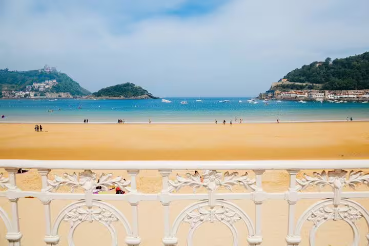 View from ornate white balcony overlooking La Concha beach and bay in San Sebastian, Spain
