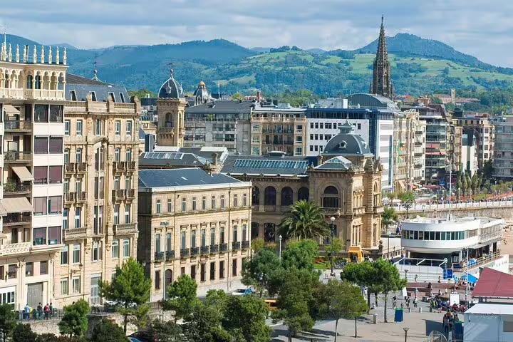 San Sebastian Old Town historic buildings and church spire with green mountains in background