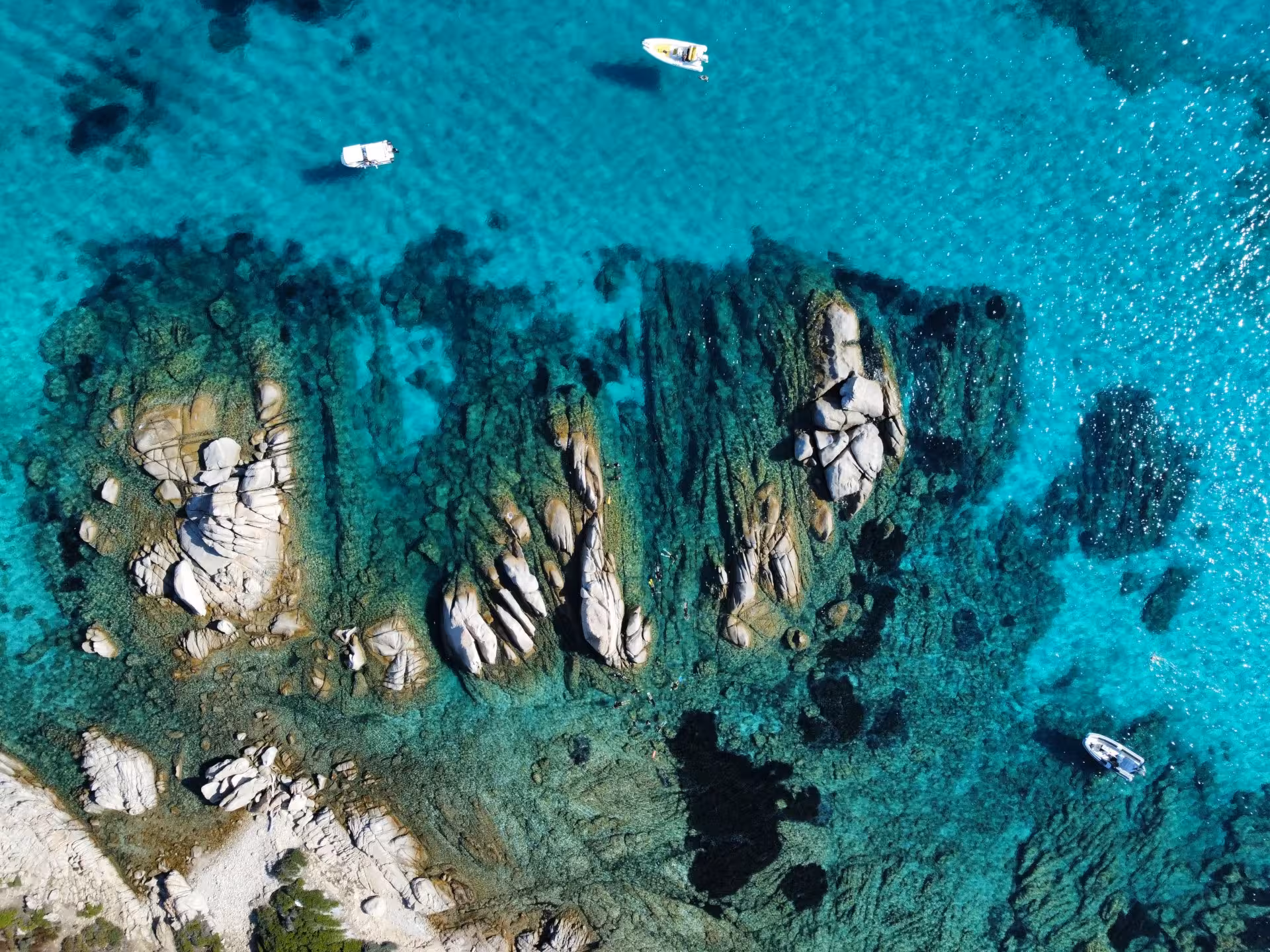 Aerial view of Molara Island's crystal-clear waters and rocky coastline, ideal for San Teodoro snorkeling tours.