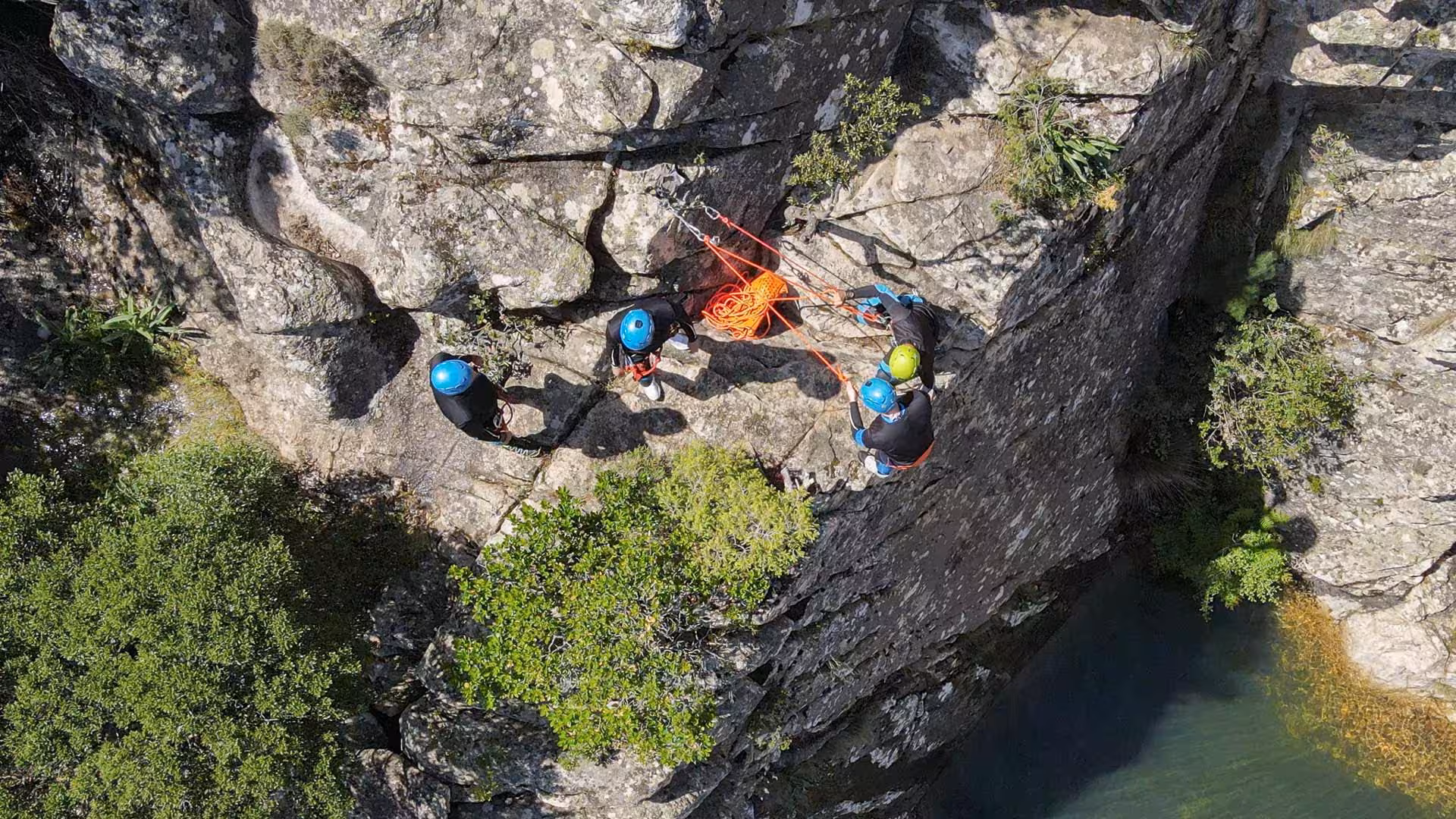 Aerial view of canyoning team scaling rocky cliffs in Rio Pitrisconi, San Teodoro, with ropes and gear.