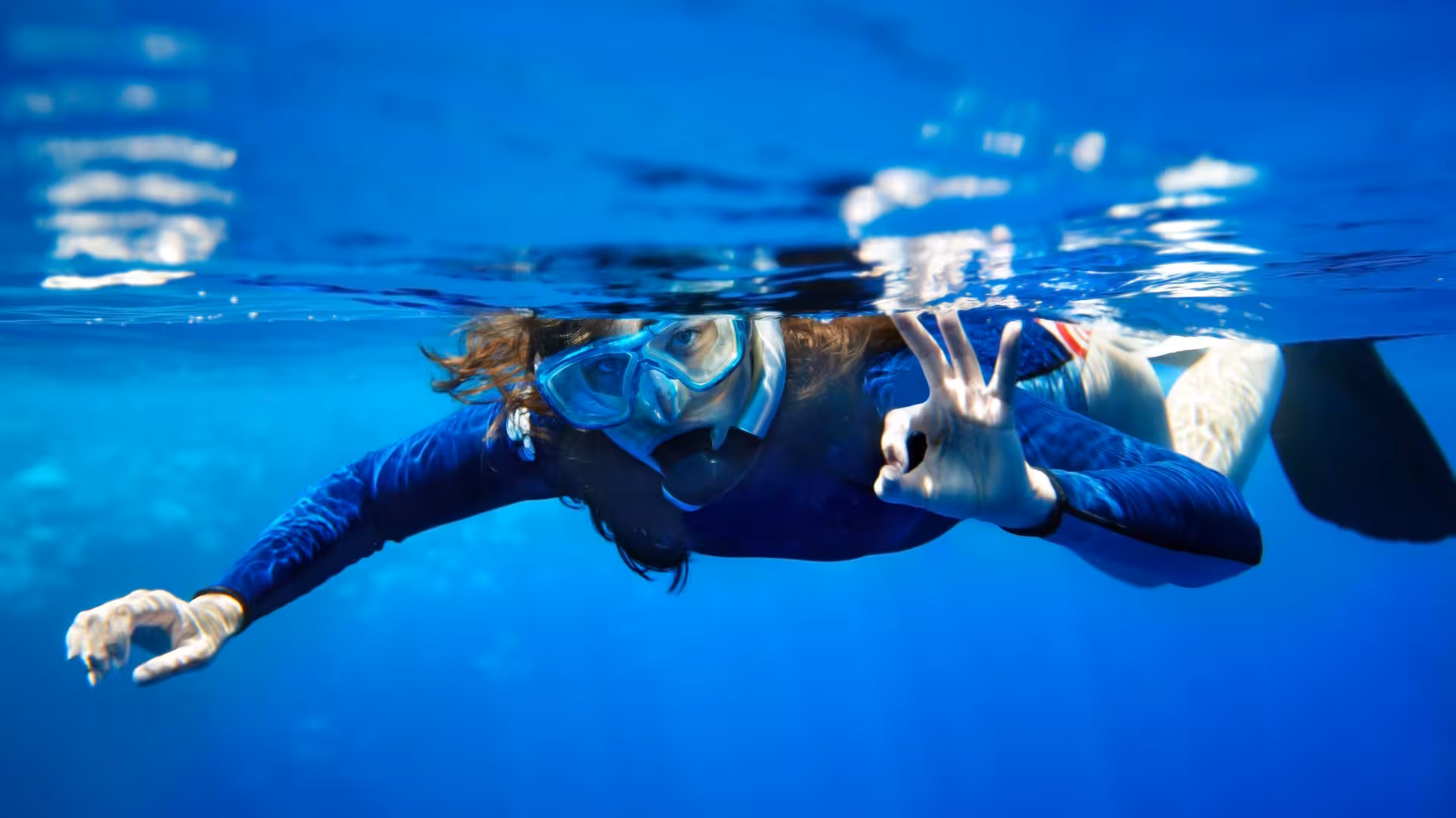 Snorkeler in clear blue waters near Tavolara, enjoying marine life exploration on a San Teodoro snorkeling tour.