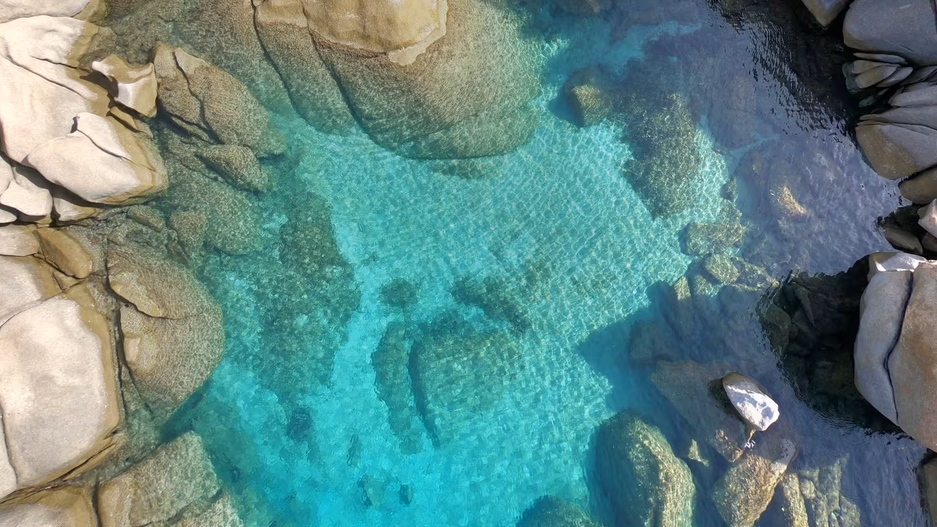 Crystal clear waters and rocky formations near Tavolara, perfect for a San Teodoro fishing excursion.