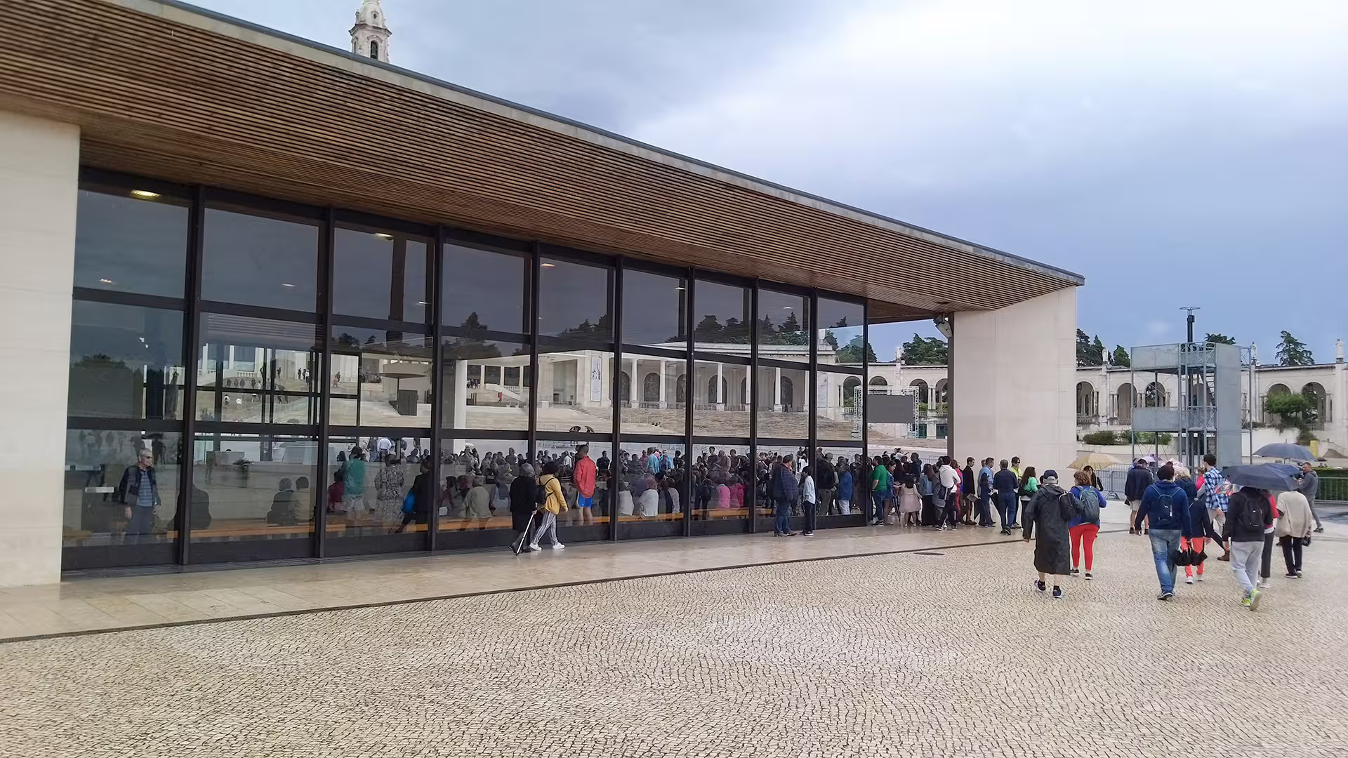 Modern building with large windows and a crowd at the Sanctuary of Fátima, perfect stop on a private Lisbon to Porto tour.