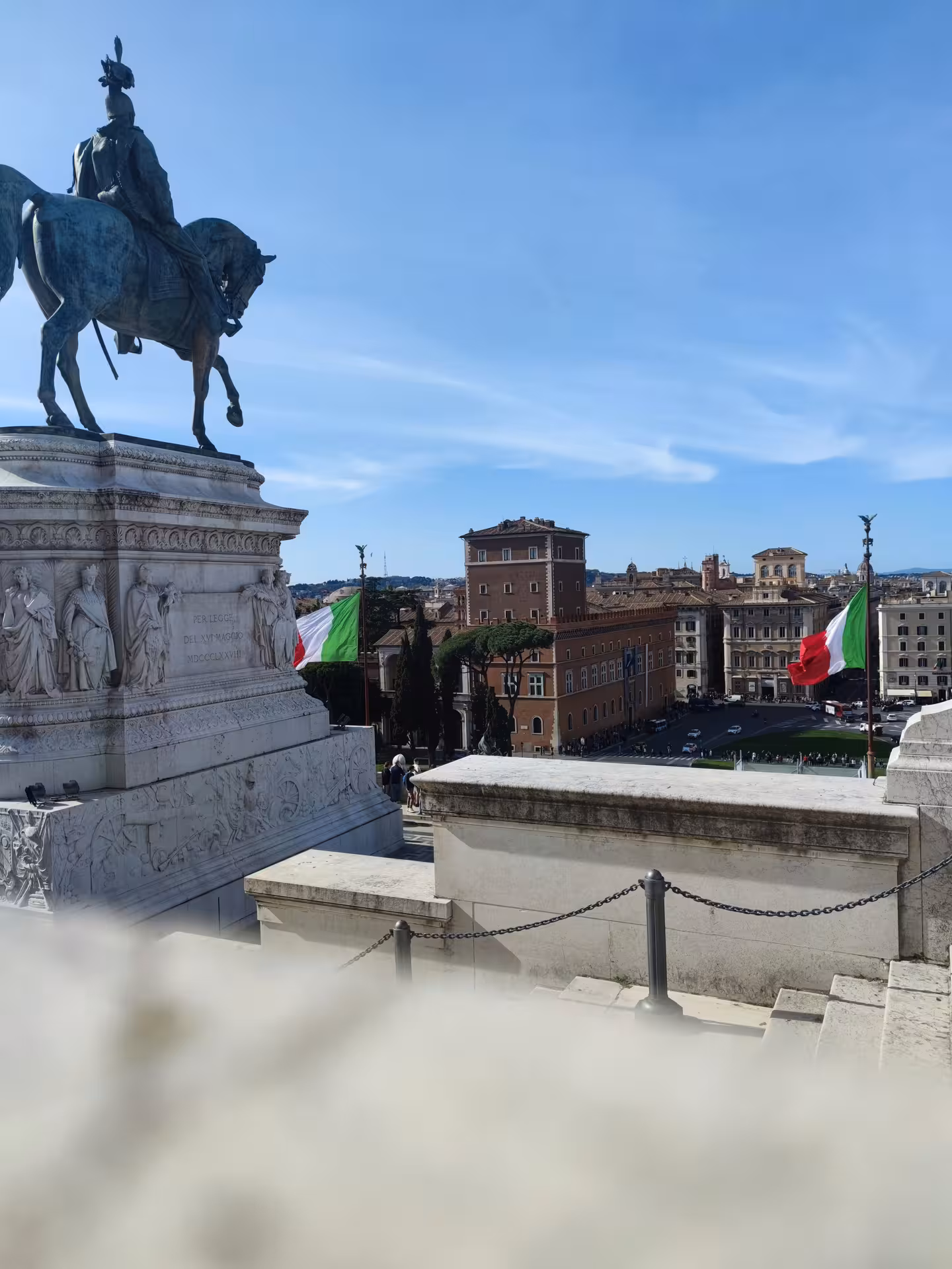 Equestrian statue and Italian flags adorn the scenic vantage point at Sant'Angelo Castle, overlooking Rome.