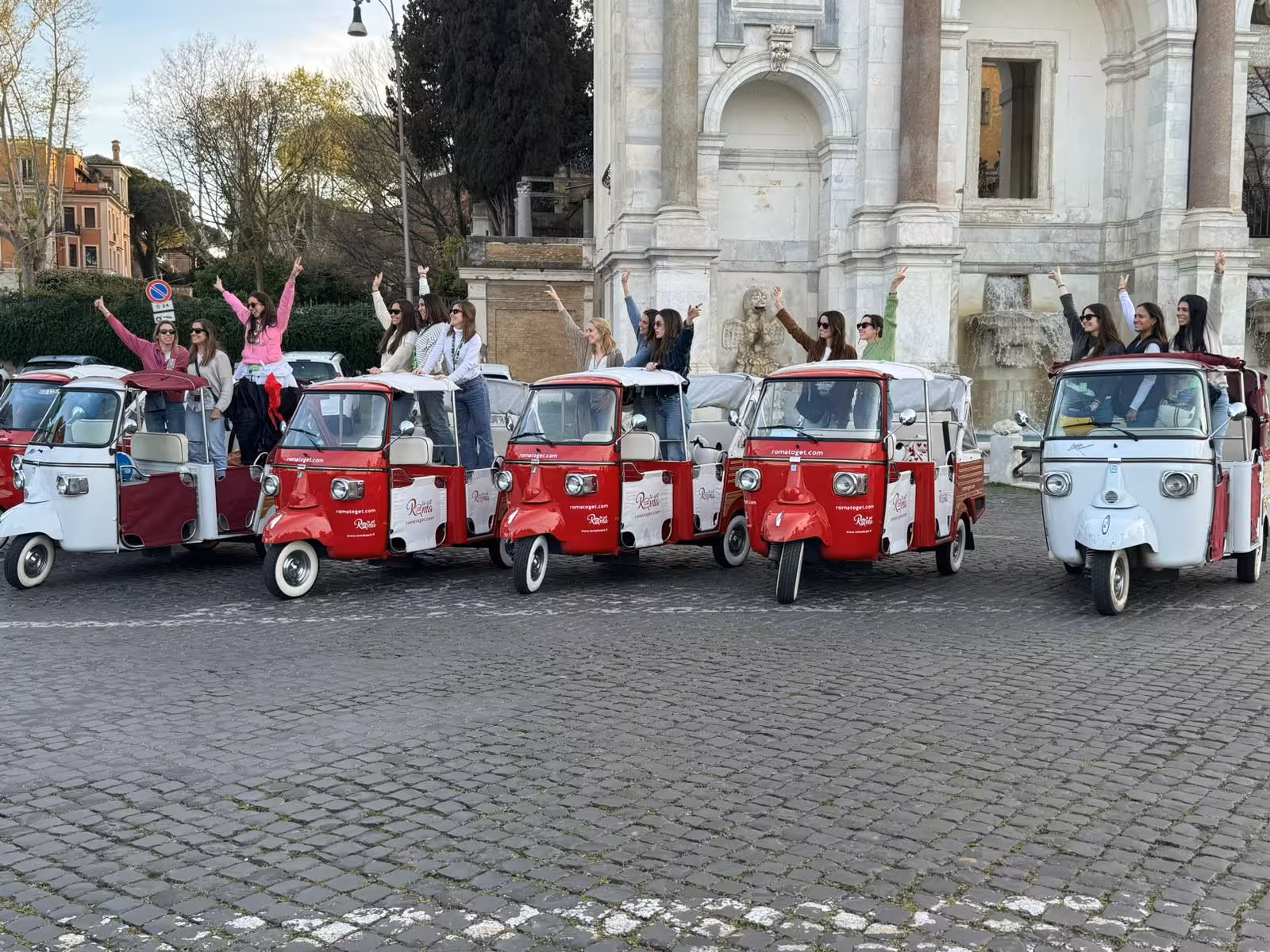 Group enjoying a fun tuk-tuk ride in front of historic architecture on the Sant'Angelo Castle Combo Tour.