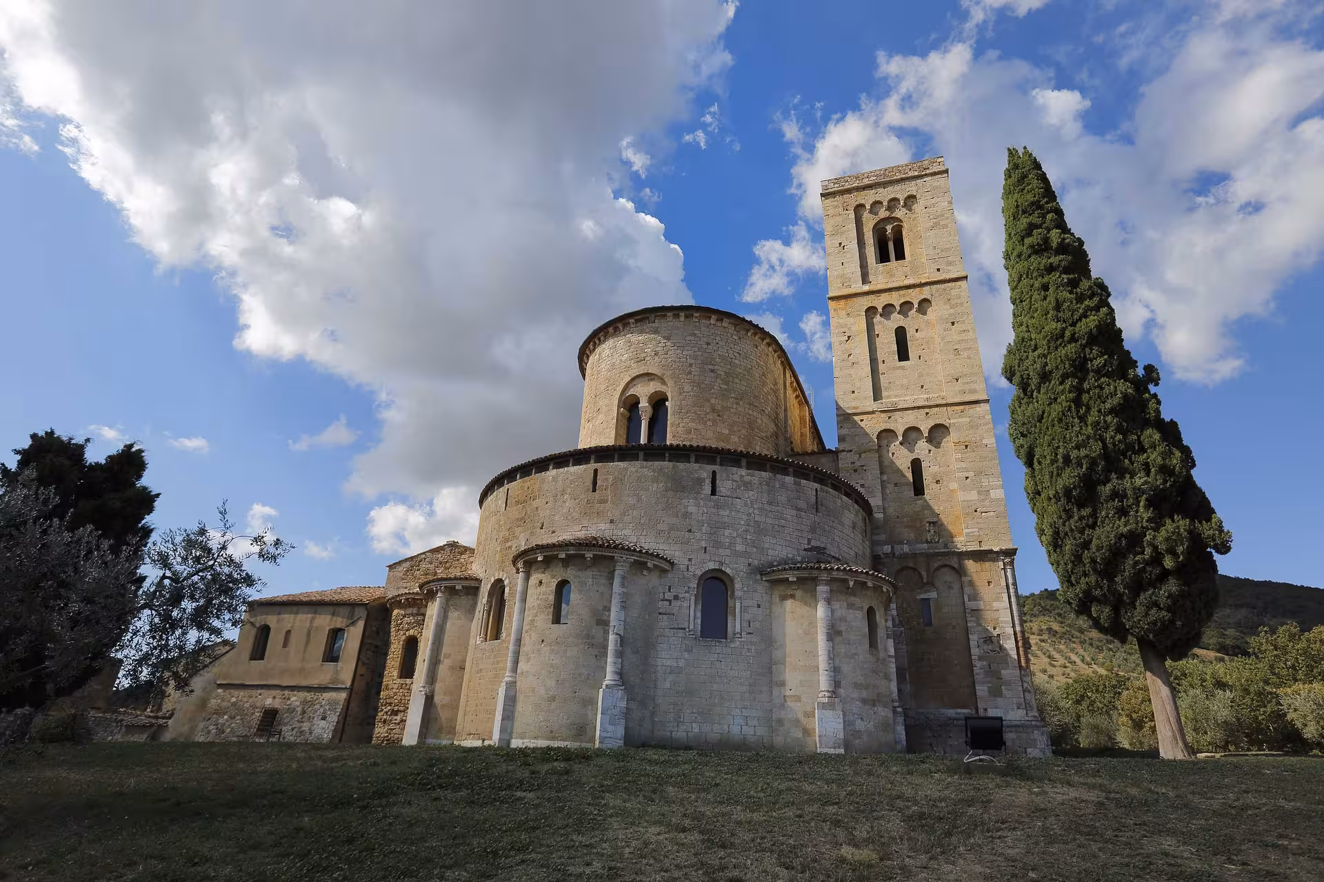 Close-up of historic Sant'Antimo Abbey under a dramatic sky, a key site for Montalcino wine and gourmet tours.