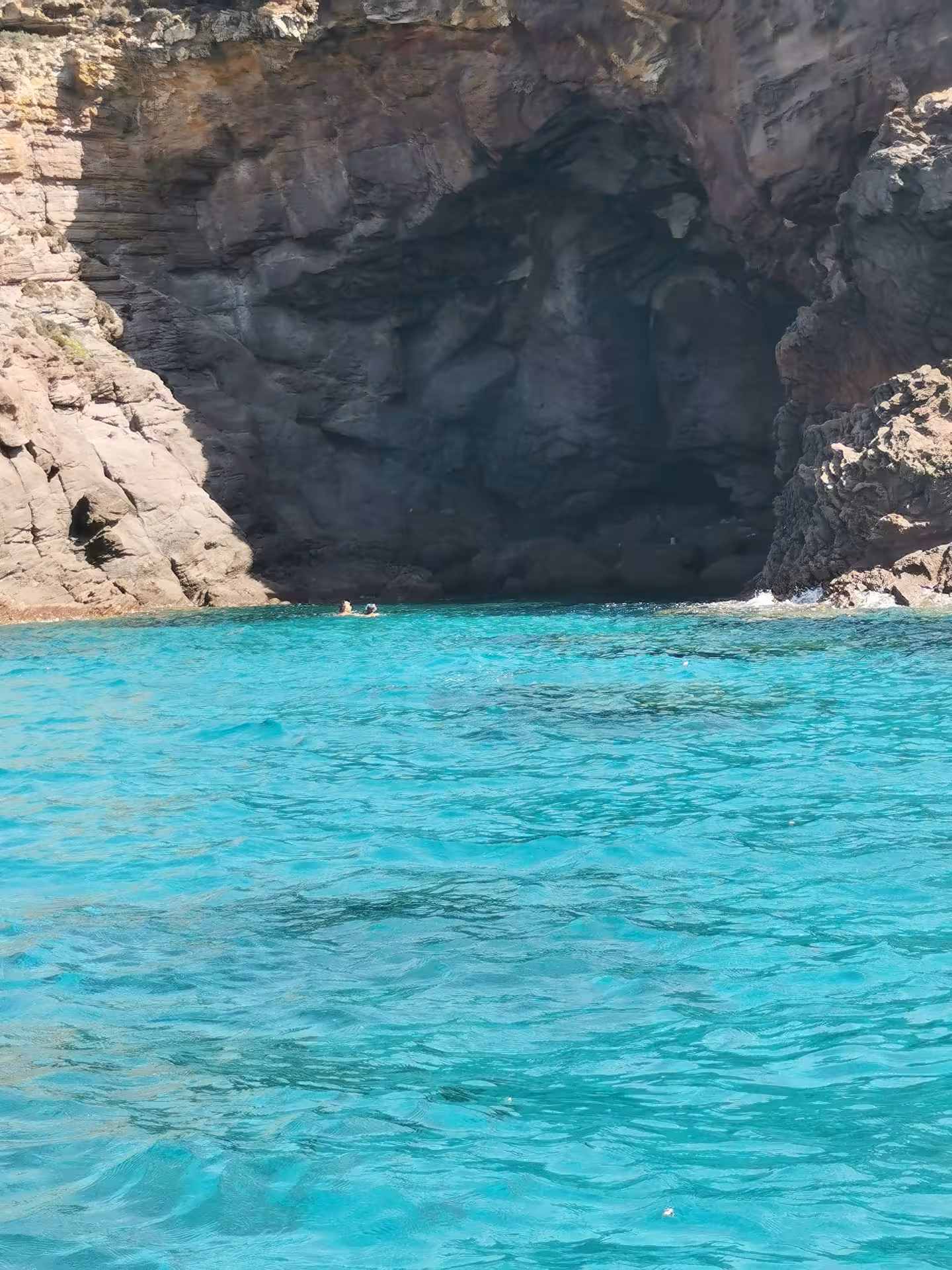 Discover hidden caves along Sant'Antioco's rugged coast during a 4-hour RIB tour in vibrant blue waters.