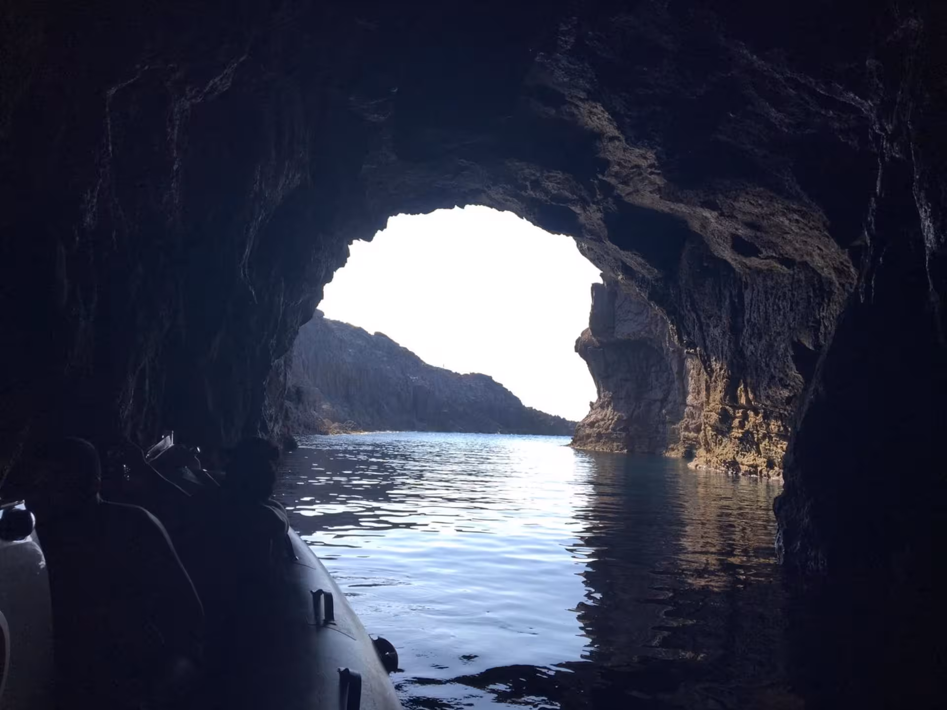 Exploring a dramatic sea cave with rugged rock formations on a Sant'Antioco RIB tour.