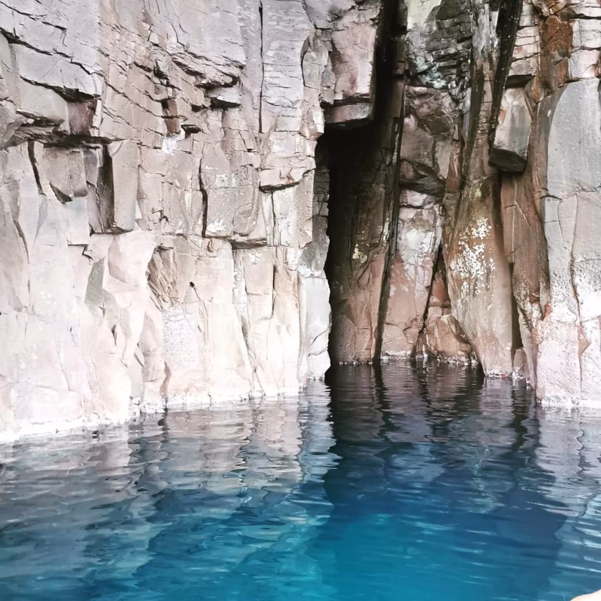 Marvel at the serene turquoise waters against dramatic rocky cliffs on the Sant'Antioco RIB tour experience.