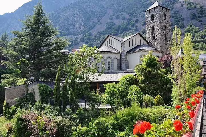Scenic view of Sant Esteve Church surrounded by lush greenery in Andorra's mountainous landscape.
