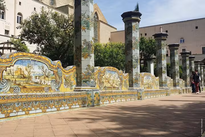 Ornate majolica-tiled benches and columns in the cloister of Santa Chiara, Naples