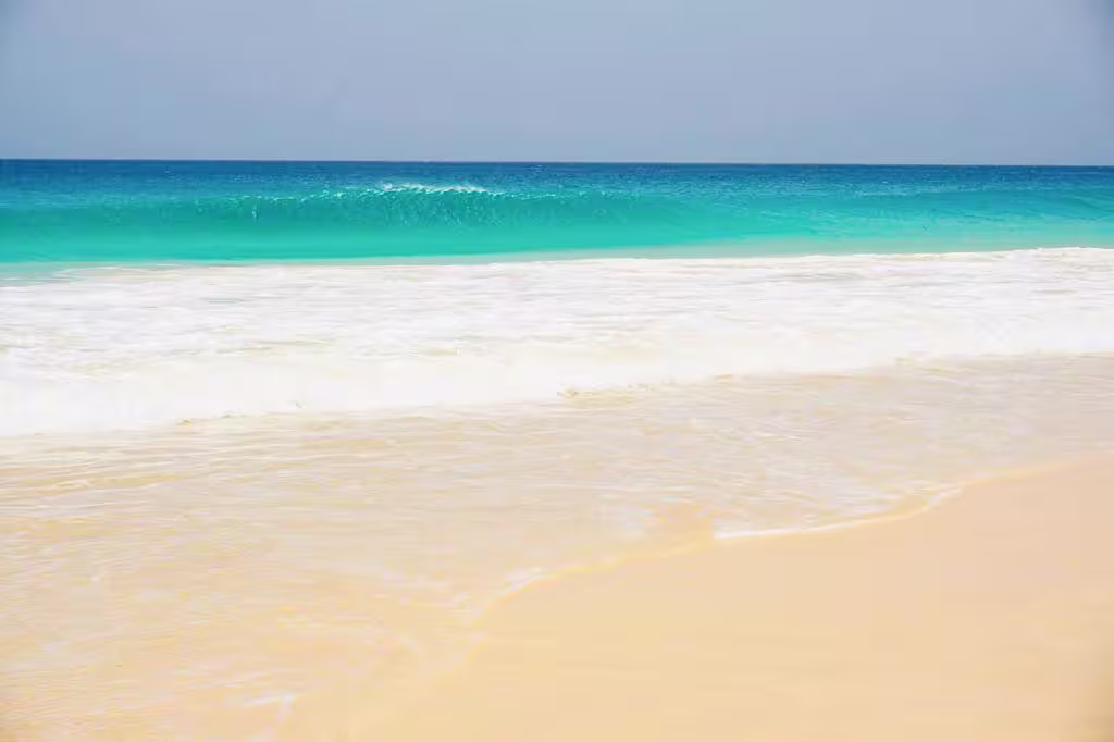 Serene Santa Mónica Beach in Boa Vista with golden sands and turquoise waves perfect for relaxation and exploration.
