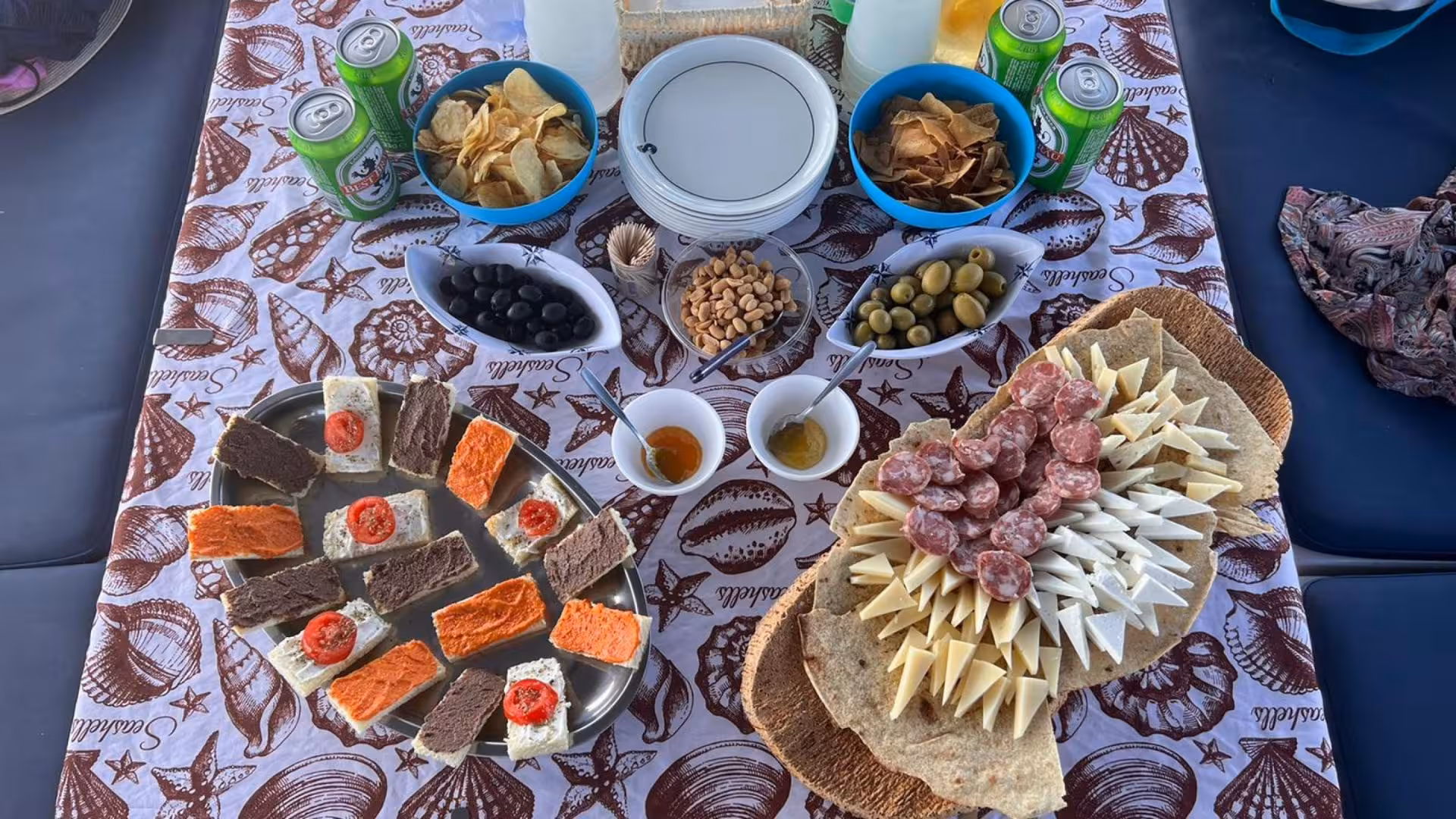 Gourmet spread of cheeses, meats, and snacks on a sailboat during the Santa Teresa di Gallura to Corsica tour.