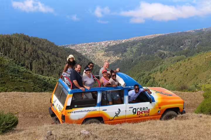 Group enjoying Santana & Peaks 4x4 tour with stunning Madeira landscape and ocean views, ideal for adventure seekers.