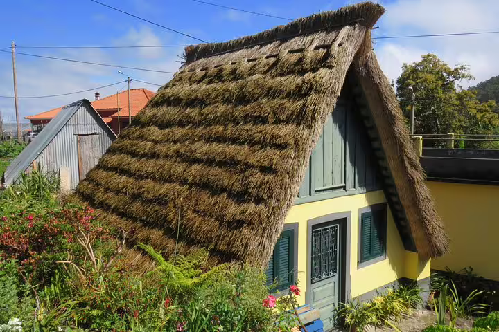 Traditional Santana house with thatched roof surrounded by lush greenery, featured in Santana & Peaks 4x4 tour excursion.