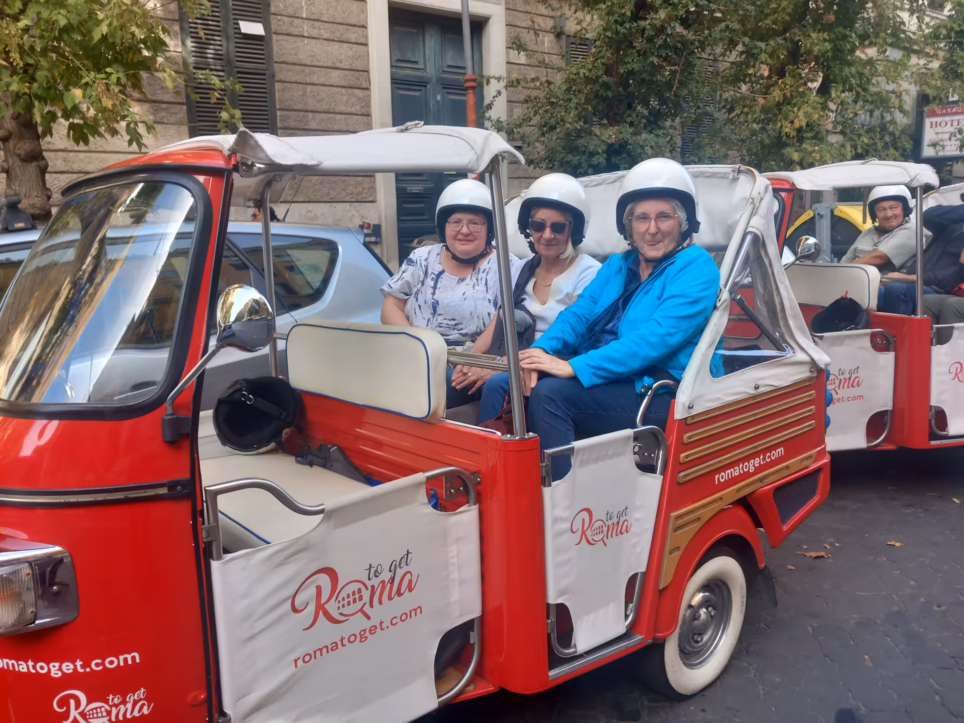 Tourists enjoy a vibrant tuk-tuk ride through Rome as part of the Sant'Angelo Castle Combo Tour experience.