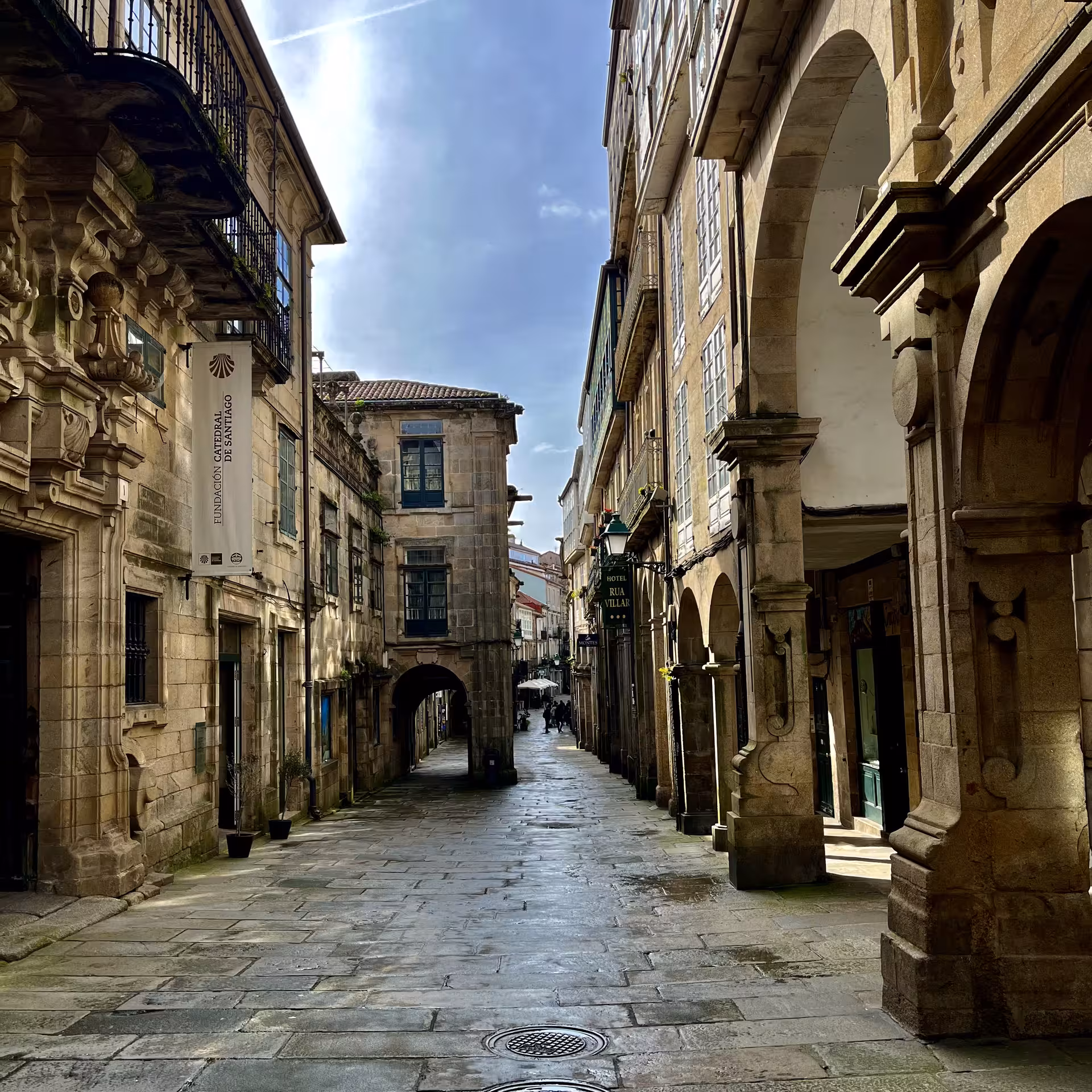 Cobbled Old Town street in Santiago de Compostela on Leyendas Locales tour near Cathedral Museum arches
