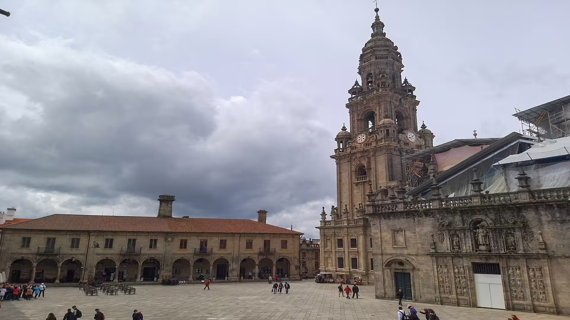 Santiago de Compostela Cathedral's impressive facade and lively plaza under dramatic clouds, ideal for a private cultural tour.