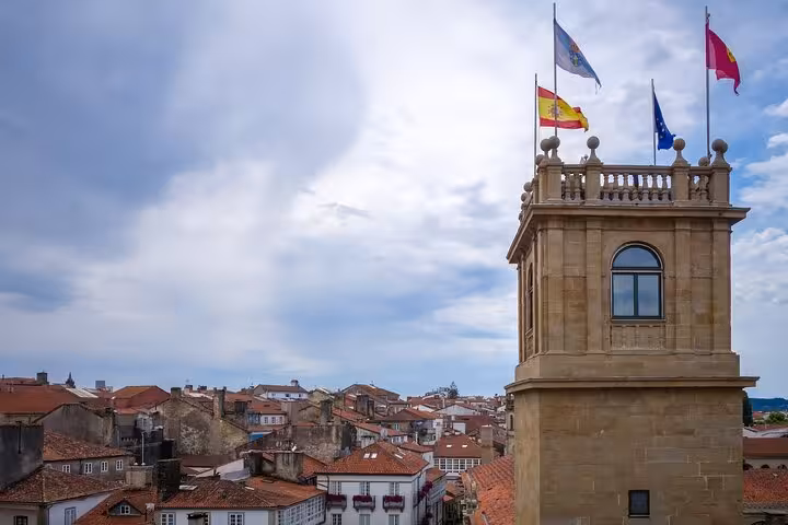 Scenic view of Santiago de Compostela with a tower adorned with flags during a private guided city walk.