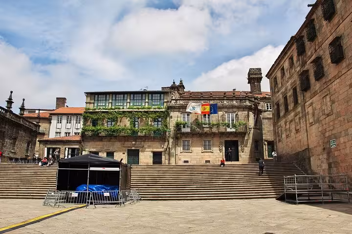 Charming stone buildings with flags and greenery in Santiago de Compostela, showcasing historic city architecture.