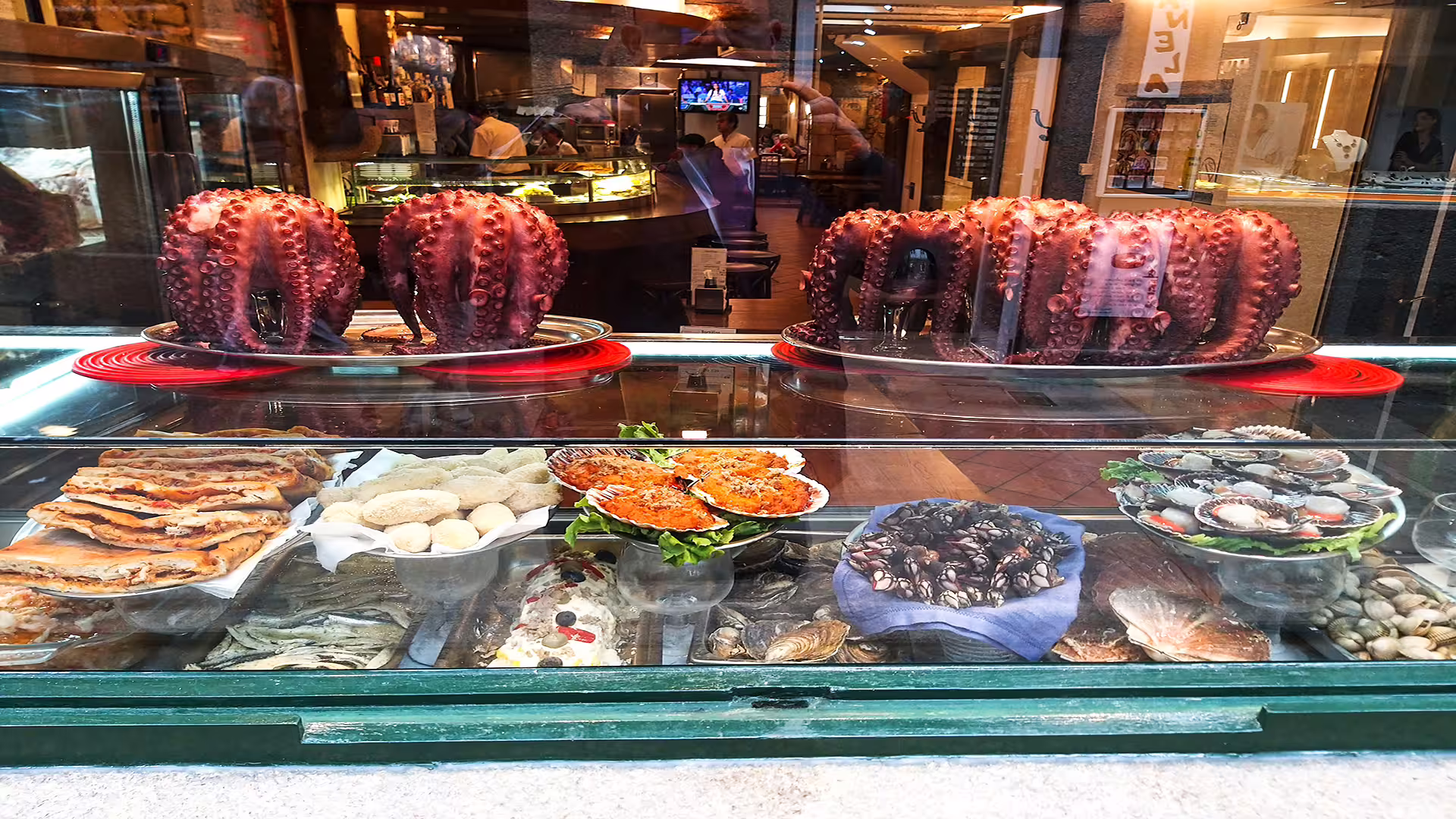 A vibrant seafood display featuring octopus and shellfish in a Santiago de Compostela restaurant, perfect for culinary tours.