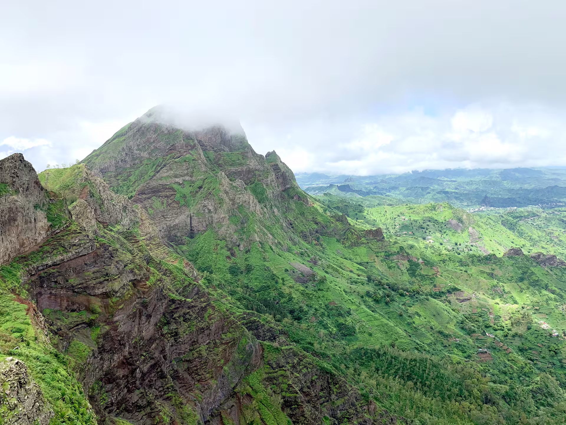 Foggy peak of Santiago Island's mountain range showcases breathtaking vistas and lush landscapes.