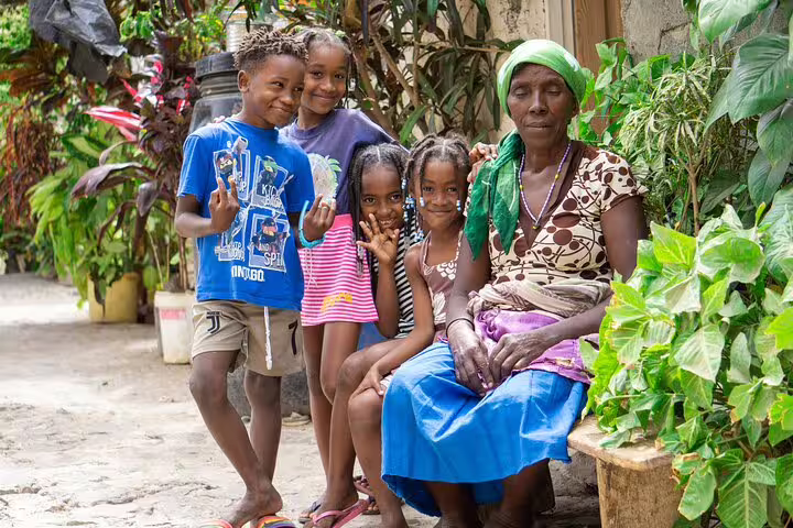 Local family posing joyfully in a garden setting on Santiago Island, Cape Verde cultural tour.