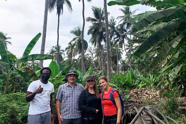 Travelers posing amidst lush banana and palm trees on a guided nature tour in Santiago Island, Cape Verde.