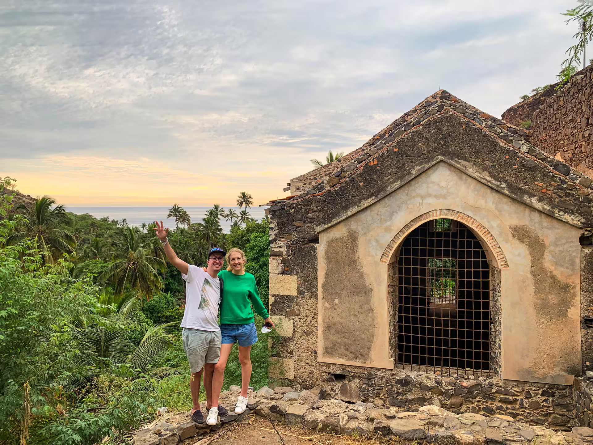 Couple at historic stone chapel ruins in Cidade Velha, Santiago Island tour with palm valley and ocean sunset