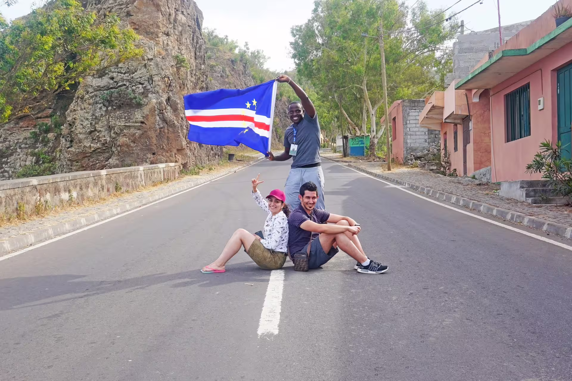 Travelers with Cape Verde flag on Santiago Island road near Cidade Velha, fun photo stop on island tour