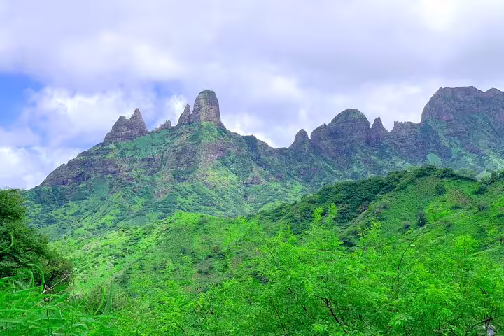 Stunning green mountainous landscape under a blue sky on Santiago Island excursion.