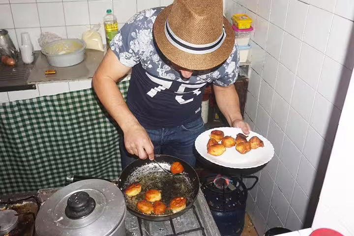 Local chef preparing traditional Cape Verdean pastries in a cozy Santiago Island kitchen during an authentic cultural tour.